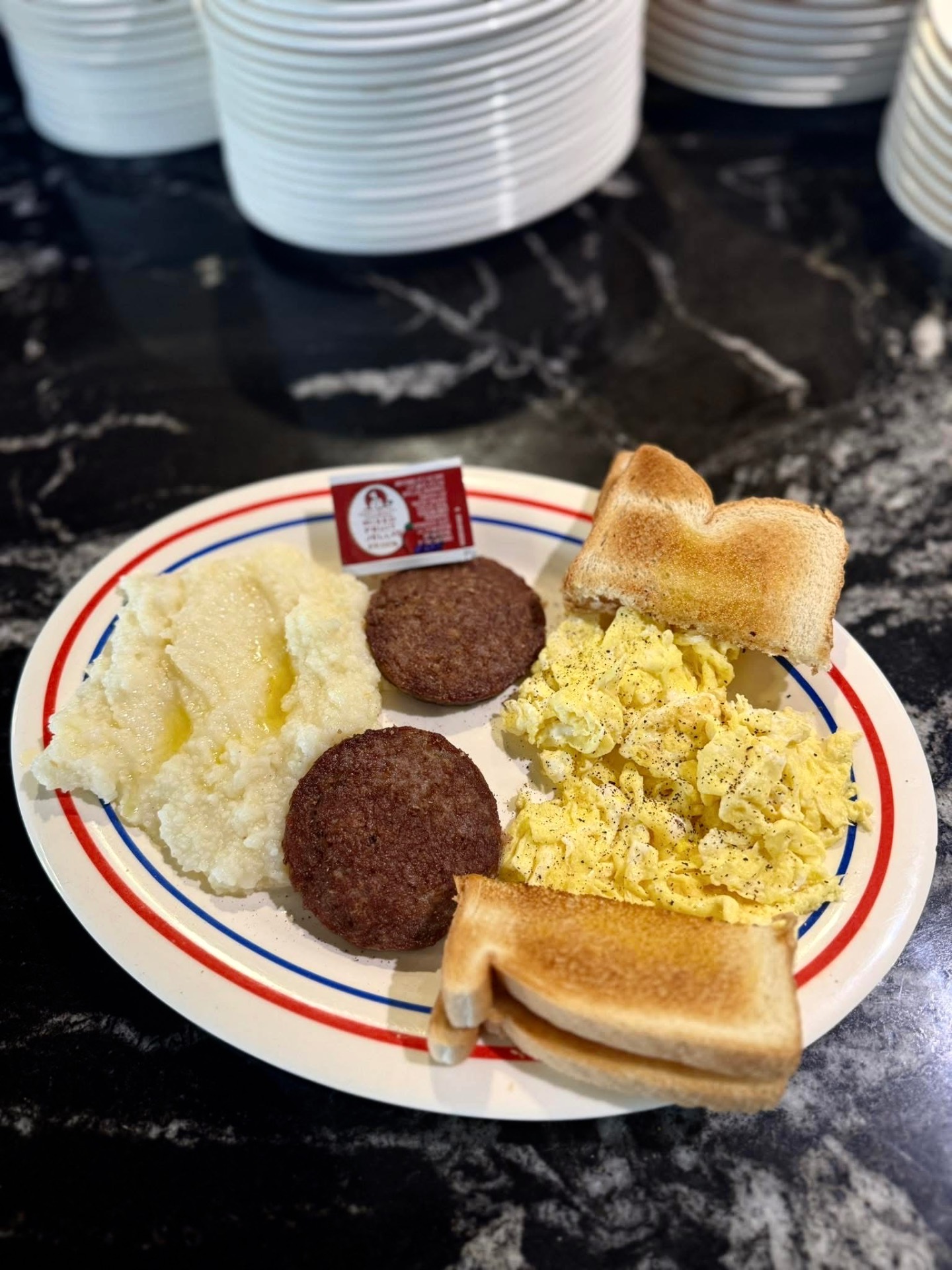 Breakfast plate with grits, sausage, eggs and toast